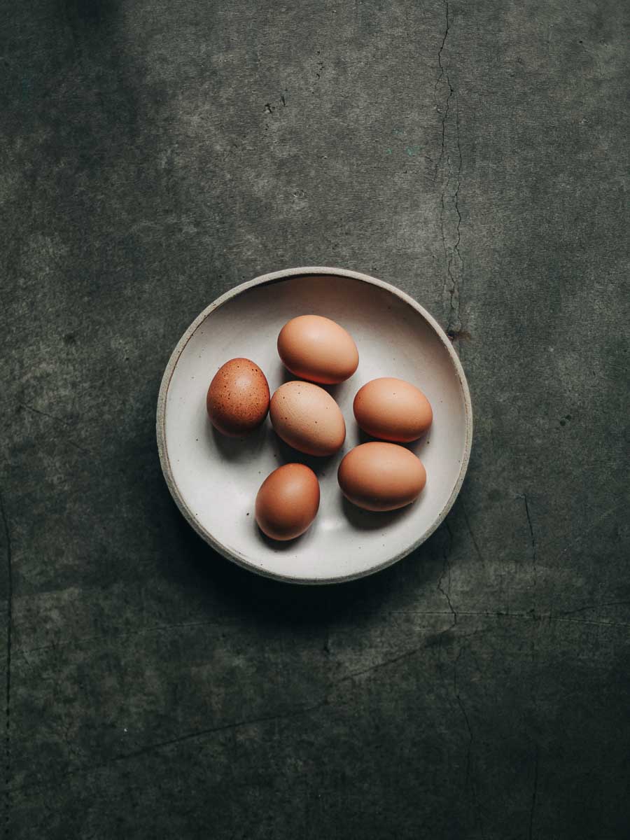 Half Dozen Brown Eggs on a Off-White Ceramic Bowl